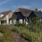 Achtertuin van een boerderij in Beneden - Leeuwen met vijver en beplanting. Tuinontwerp en tuinaanleg door Uw Tuin Hoveniers uit Malden