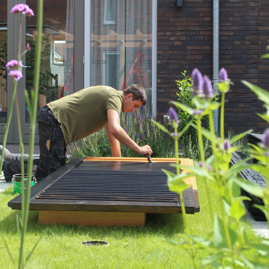 Het schilderen van een tuinoverkapping door een hovenier van Uw Tuin Hoveniers uit Malden