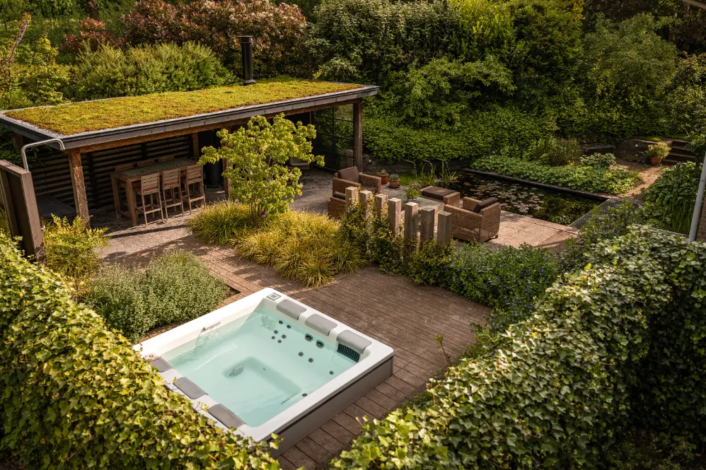 Groene achtertuin met jacuzzi in Huissen. Tuinontwerp en tuinaanleg door Uw Tuin Hoveniers uit Malden.