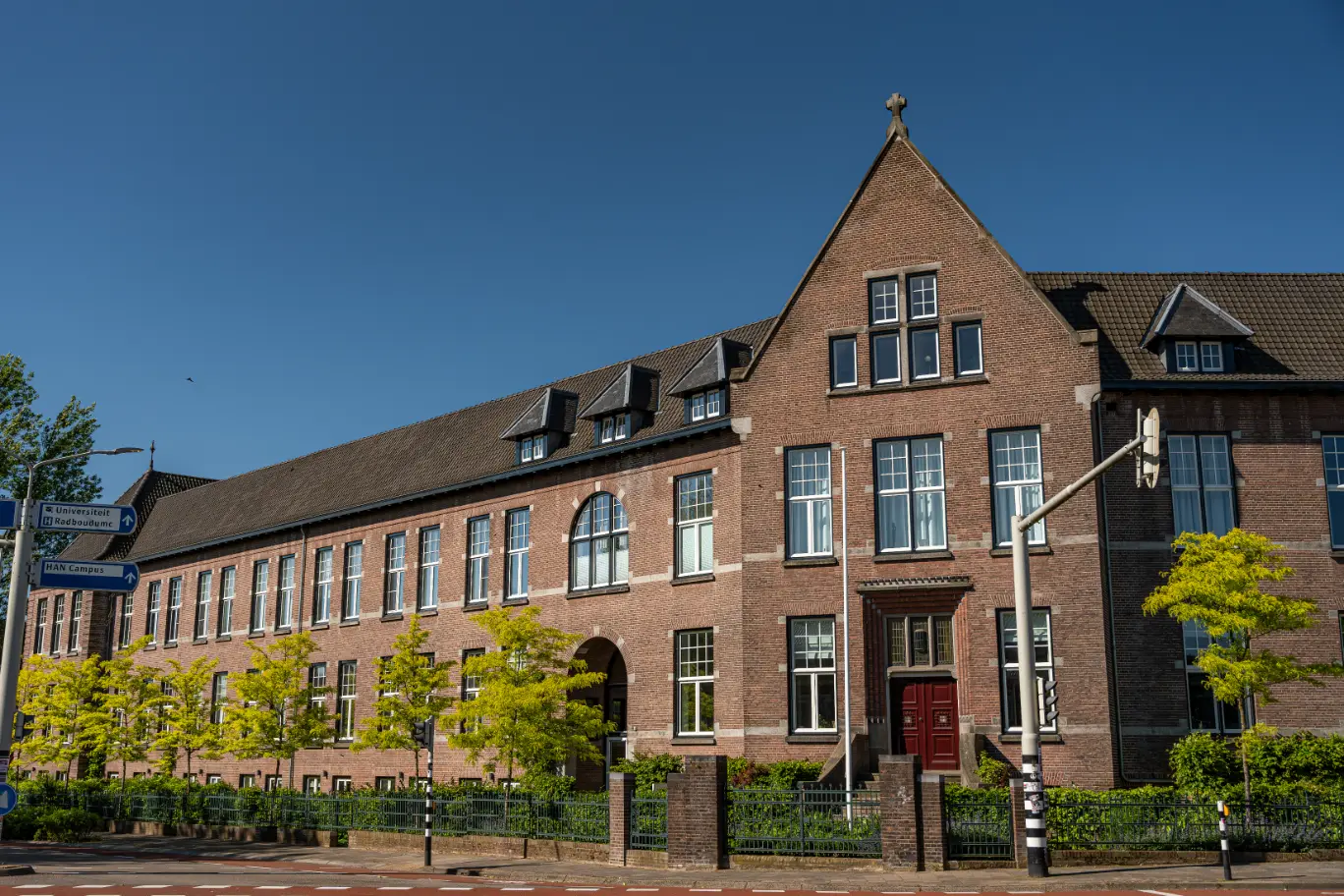 Vooraanzicht van het Cum Laude pand in Nijmegen. Tuinontwerp en tuinaanleg door Uw Tuin Hoveniers uit Malden.